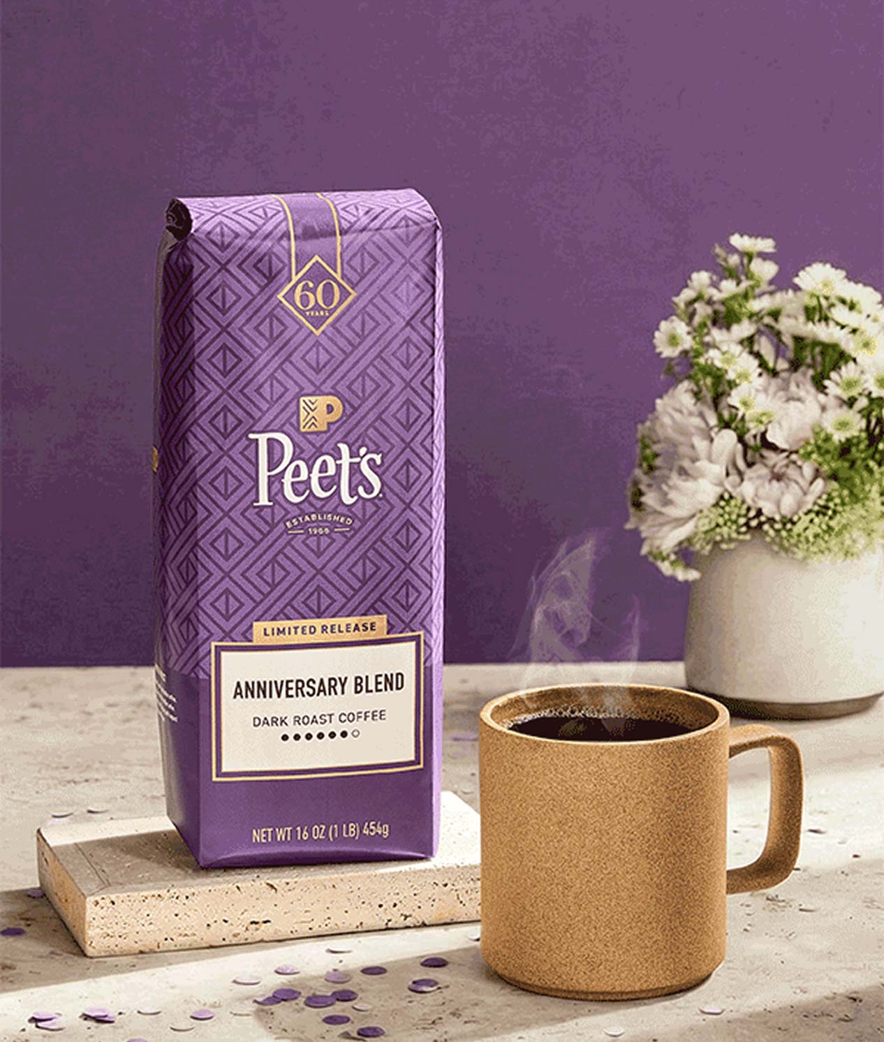 Peet's coffee package with a mug of coffee on a table against a purple background