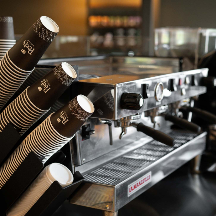 An espresso machine at a Peet's coffeebar with Peet's paper cups