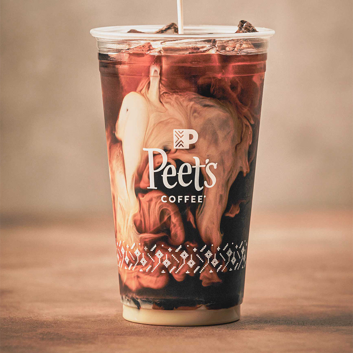 Milk being poured into cup of iced coffee