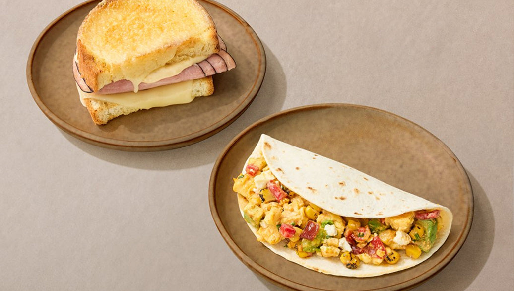 Two plates with a sandwich and a wrap on a beige background