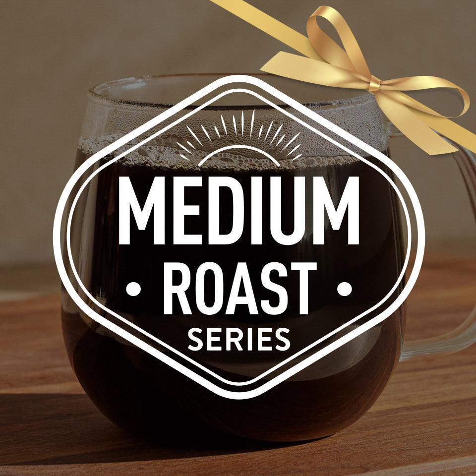 Glass of medium roast coffee with a gold bow on a wooden surface